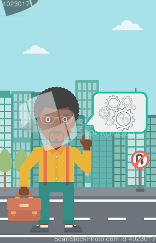 Image of Businessman pointing at cogwheels.