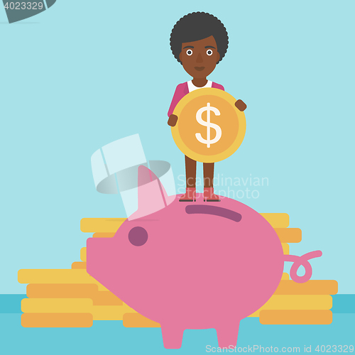 Image of Business woman putting coin in piggy bank.