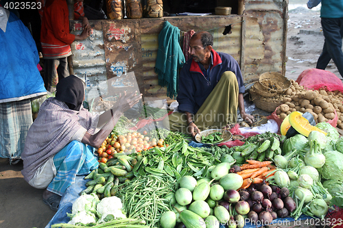 Image of Tribal villagers bargain for vegetables. Sonakhali, West Bengal, India