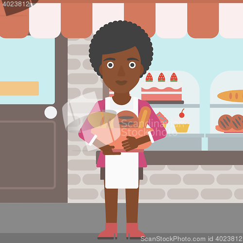 Image of Baker holding basket with bakery products.