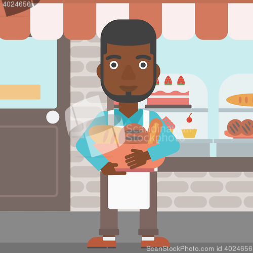 Image of Baker holding basket with bakery products.