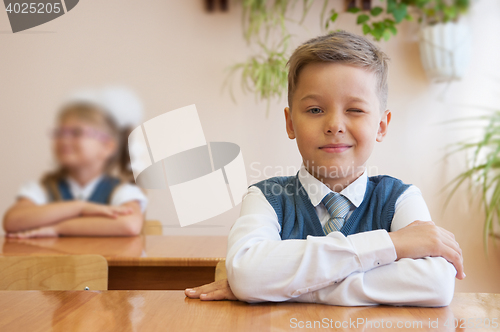 Image of Happy schoolboy sitting at desk