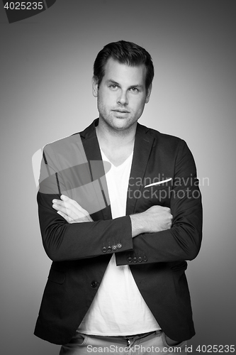 Image of Portrait of a smart young man standing with arms crossed.