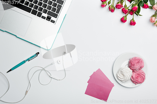 Image of Office desk table with computer, supplies, flowers