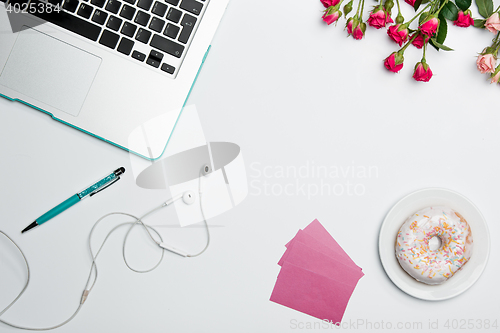 Image of Office desk table with computer, supplies, flowers