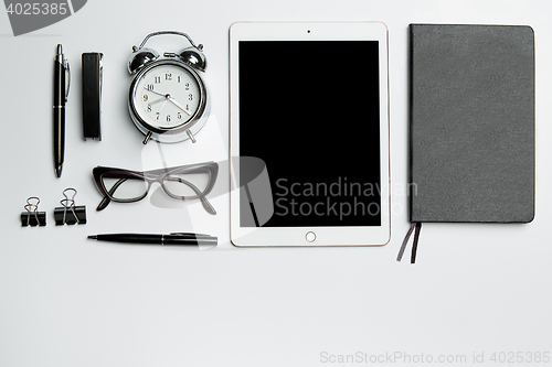 Image of Office desk table with laptop, supplies, phone and coffee cup.