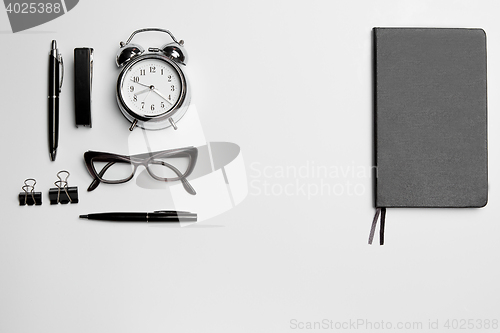 Image of The clock, pen, and glasses on white background