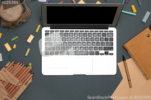 Image of Office desk table with computer, supplies, flowers