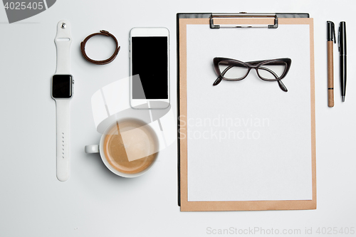 Image of Office desk table with cup, supplies, phone on white