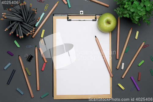 Image of Office desk table with pencils, supplies and flowers