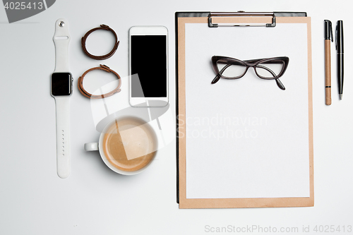 Image of Office desk table with cup, supplies, phone on white