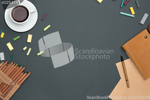 Image of Office desk table with pencils, supplies and cup