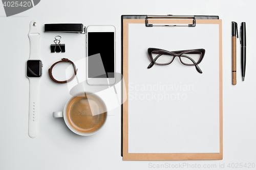 Image of Office desk table with cup, supplies, phone on white