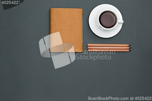 Image of Office desk table with pencils, notebook and a cup of coffee