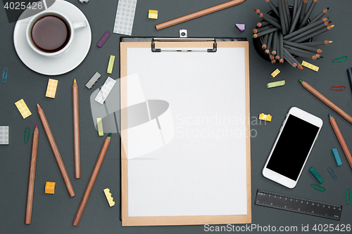 Image of Office desk table with pencils, supplies, phone and cup