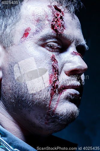 Image of Bloody Halloween theme: crazy killer as young man with blood