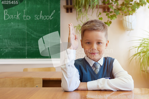 Image of Happy schoolboy sitting at desk