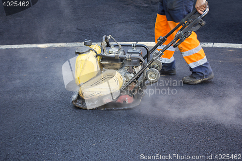 Image of Worker use vibratory plate compactor 