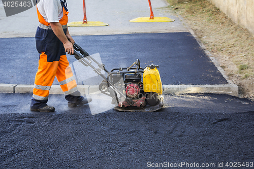 Image of Worker use vibratory plate compactor