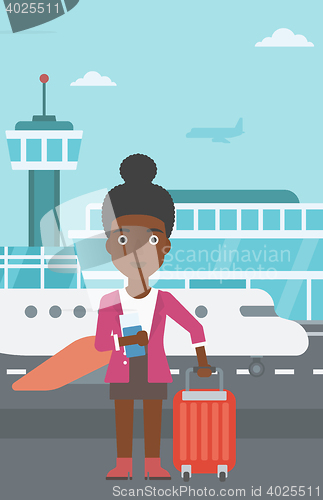 Image of Woman with suitcase and ticket at the airport.