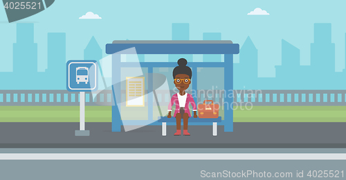 Image of Woman waiting for bus at the bus stop.