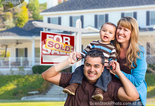 Image of Young Family in Front of Sold Real Estate Sign and House