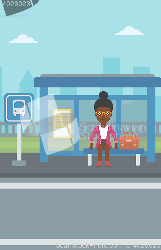 Image of Woman waiting for bus at the bus stop.