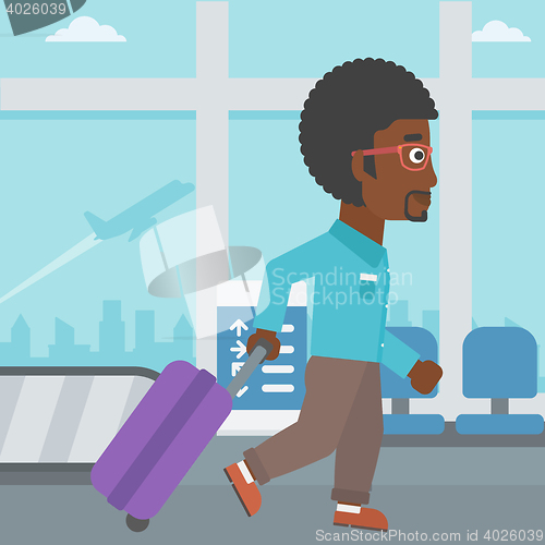 Image of Man walking with suitcase at the airport.