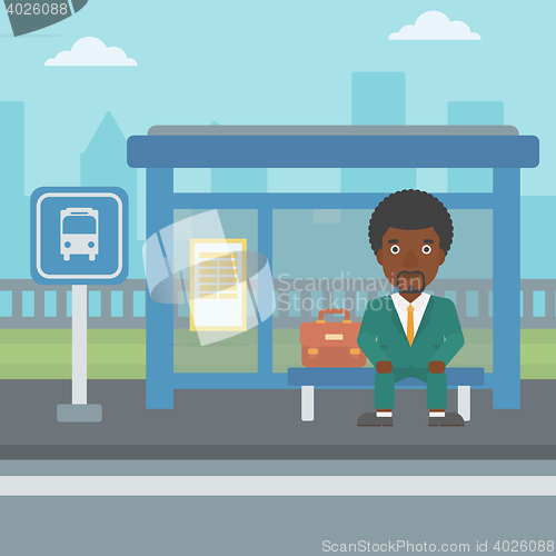 Image of Man waiting for bus at the bus stop.