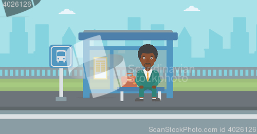 Image of Man waiting for bus at the bus stop.