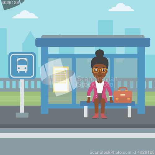 Image of Woman waiting for bus at the bus stop.