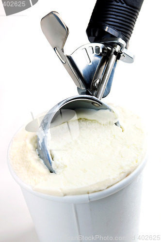 Image of Tub of vanilla ice cream with a scoop