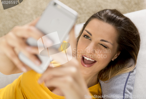 Image of Happy woman texting