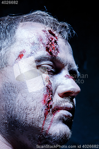 Image of Bloody Halloween theme: crazy killer as young man with blood