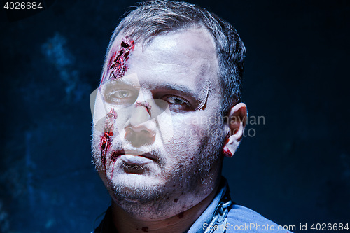 Image of Bloody Halloween theme: crazy killer as young man with blood