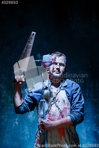 Image of Bloody Halloween theme: crazy killer as butcher with saw