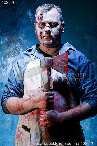 Image of Bloody Halloween theme: crazy killer as butcher with an ax