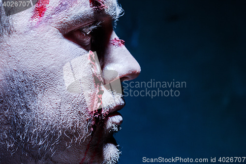 Image of Bloody Halloween theme: crazy killer as young man with blood