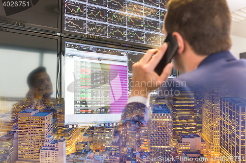 Image of Stock trader looking at computer screens.