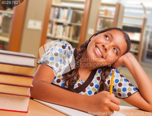 Image of Hispanic Girl Student Daydreaming While Studying in Library