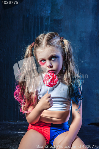 Image of The funny crasy girl with candy on dark background