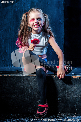 Image of The funny crasy girl with candy on dark background