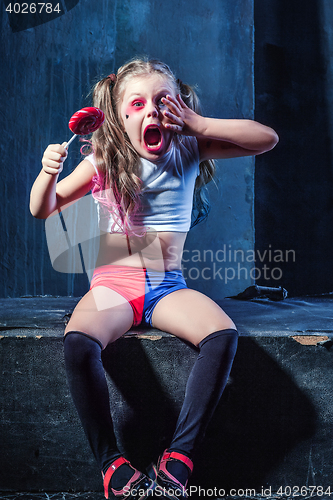 Image of The funny crasy girl with candy on dark background