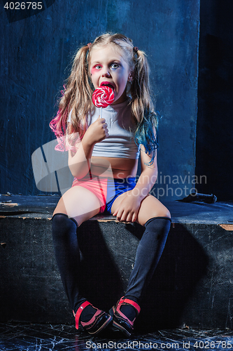 Image of The funny crasy girl with candy on dark background