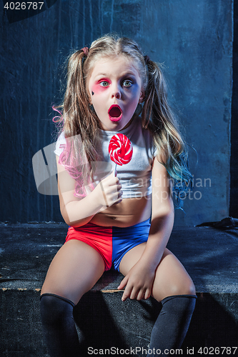 Image of The funny crasy girl with candy on dark background