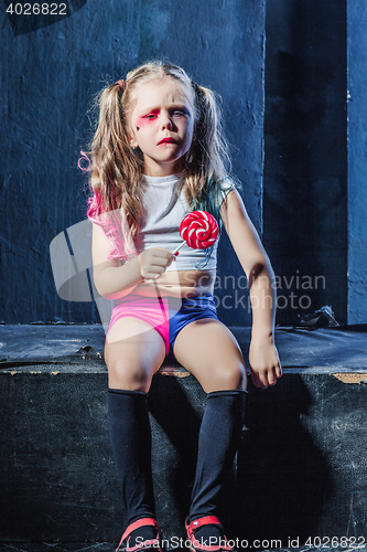 Image of The crasy girl with candy on dark background