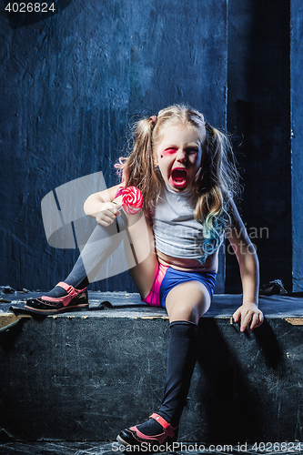 Image of The crasy girl with candy on dark background