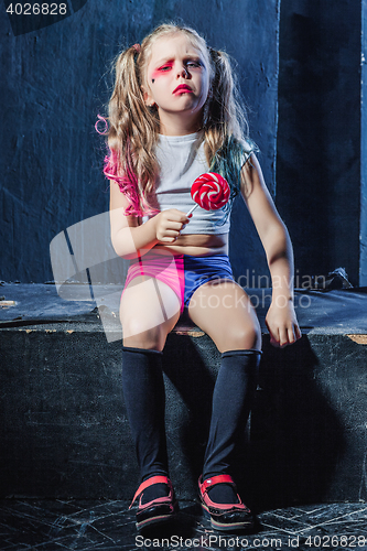 Image of The crasy girl with candy on dark background