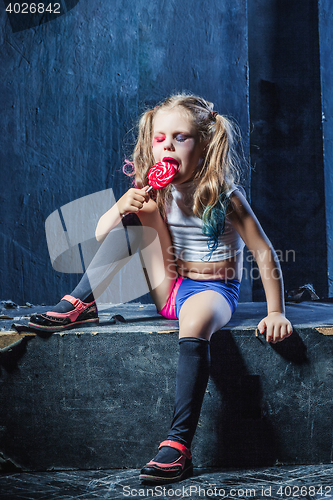 Image of The crasy girl with candy on dark background