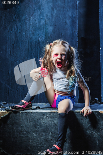 Image of The crasy girl with candy on dark background